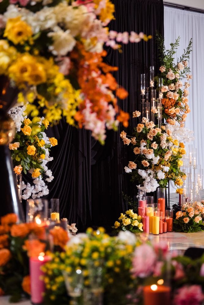 Vibrant floral installation concept with candles and black drapery